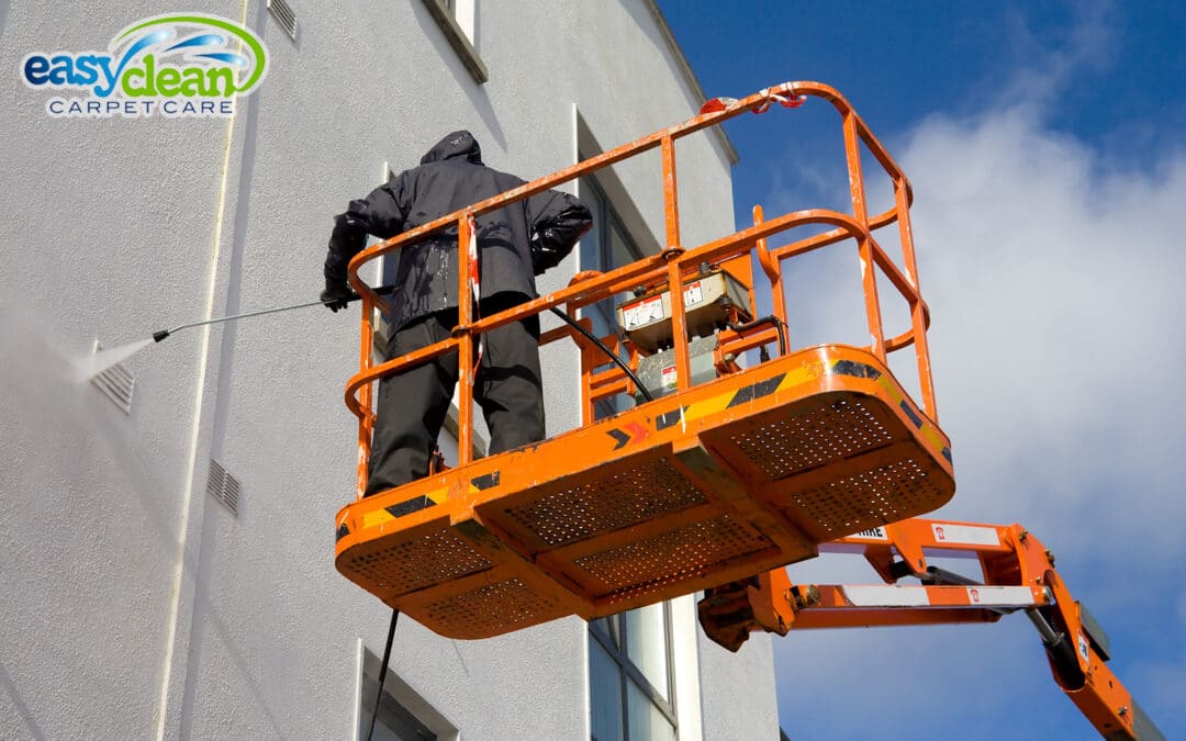 Worker On a Platform Pressure Washing a Building